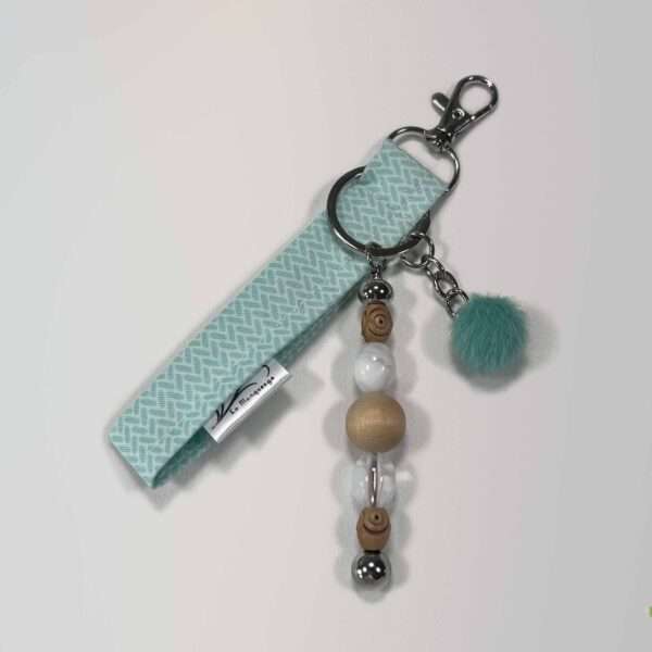 Porte-clés turquoise en tissu recyclé avec perles en bois et marbrées blanches, pompon turquoise, collection Duo Mix. La Marqueuze